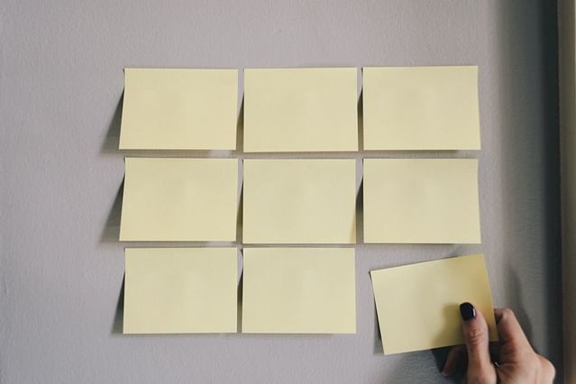 "Empty sticky notes on a wall"